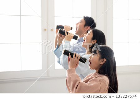 A family of three eating ehomaki whole in a bright living room A family of three eating ehomaki whole in a bright living room 135227574