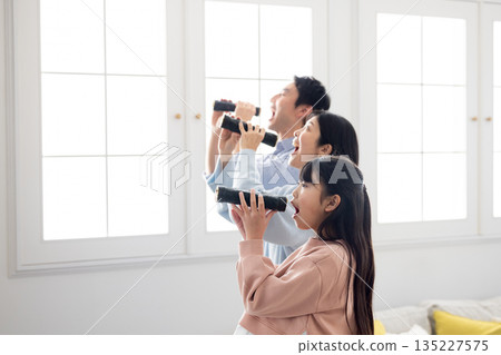 A family of three eating ehomaki whole in a bright living room A family of three eating ehomaki whole in a bright living room 135227575