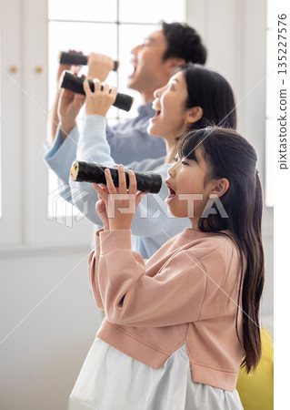 A family of three eating ehomaki whole in a bright living room A family of three eating ehomaki whole in a bright living room 135227576