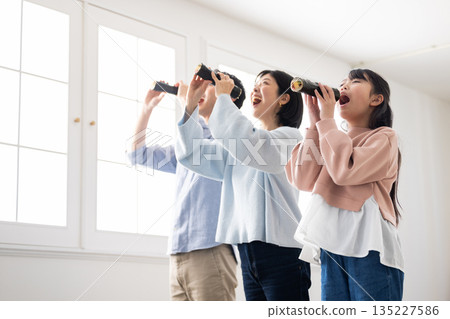 一家三口在明亮的客廳裡吃著整張江戶捲。 135227586