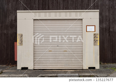 A closeup shot of automatic metal roller door used in factory, storage, garage, and industrial warehouse. The corrugated and foldable metal sheet offer space saving and provide urban and rustic feel A closeup shot of automatic metal roller door used in factory, storage, garage, and industrial warehouse. The corrugated and foldable metal sheet offer space saving and provide urban and rustic feel 135227677