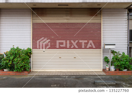 A closeup shot of automatic metal roller door used in factory, storage, garage, and industrial warehouse. The corrugated and foldable metal sheet offer space saving and provide urban and rustic feel A closeup shot of automatic metal roller door used in factory, storage, garage, and industrial warehouse. The corrugated and foldable metal sheet offer space saving and provide urban and rustic feel 135227760