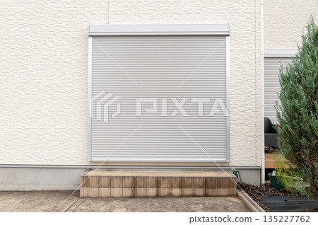 A closeup shot of automatic metal roller door used in factory, storage, garage, and industrial warehouse. The corrugated and foldable metal sheet offer space saving and provide urban and rustic feel A closeup shot of automatic metal roller door used in factory, storage, garage, and industrial warehouse. The corrugated and foldable metal sheet offer space saving and provide urban and rustic feel 135227762