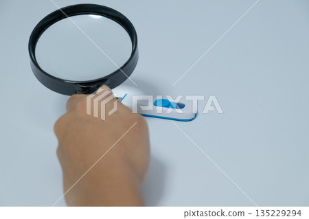 一手拿著放大鏡查看U盤 135229294