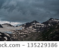 Mountain range partially covered by clouds and snow near a glacier on an overcast day in Caucasus 135229386