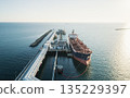 Aerial view of a large oil tanker docked at a pier in the port in process of loading. 135229397