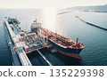 Aerial view of a large oil tanker docked at a pier in the port in process of loading. 135229398