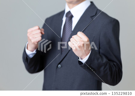 穿著西裝的中年男性商人握緊拳頭 穿著西裝的中年男性商人握緊拳頭 135229810