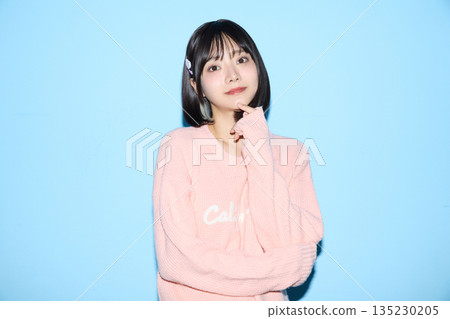 Portrait of a young Asian woman posing cutely against a blue background 135230205