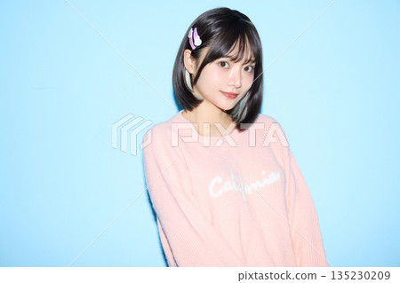 Portrait of a young Asian woman posing cutely against a blue background 135230209