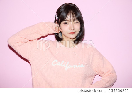 一位年輕亞洲女性在粉紅色背景下擺出可愛姿勢的肖像照 一位年輕亞洲女性在粉紅色背景下擺出可愛姿勢的肖像照 135230221
