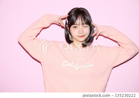 Portrait of a young Asian woman posing cutely against a pink background 135230222