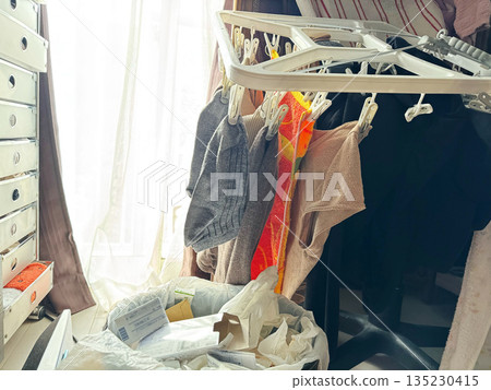 Woman taking in laundry and trash can Woman taking in laundry and trash can 135230415