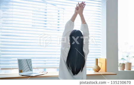 A woman in her twenties operating a laptop 135230670