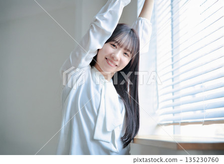 一位二十多歲女性的美麗肖像，她伸展著身體 135230760