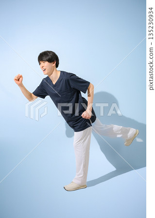 A young male nurse or doctor wearing a scrub on a light blue background, smiling in a running pose at the start, looking for a job or changing jobs, full body A young male nurse or doctor wearing a scrub on a light blue background, smiling in a running pose at the start, looking for a job or changing jobs, full body 135230934