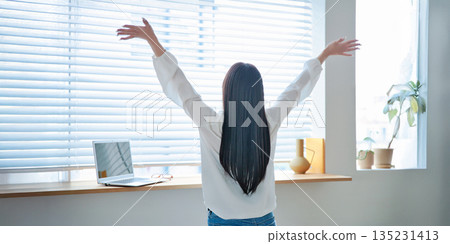 A woman in her twenties operating a laptop 135231413