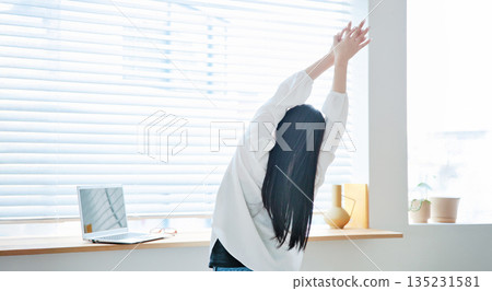 A woman in her twenties operating a laptop 135231581