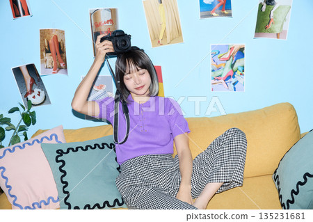 一位年輕的亞洲女性在家中享受她的愛好和私人時光。 135231681