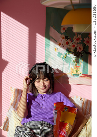 Portrait of young Asian woman enjoying her hobbies and personal time at home Portrait of young Asian woman enjoying her hobbies and personal time at home 135231686
