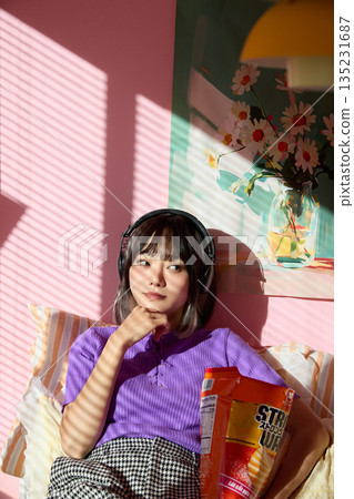 一位年輕的亞洲女性在家中享受她的愛好和私人時光。 135231687
