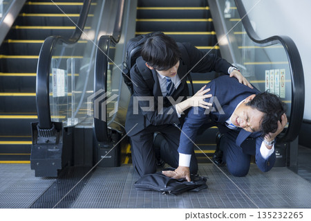 Middle-aged man collapses under escalator Middle-aged man collapses under escalator 135232265