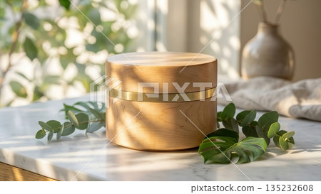 Wooden cosmetic jar mockup on marble table with green leaves. 135232608