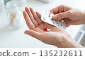 Hands holding blister pack and red capsule pill: Healthcare concept. 135232611