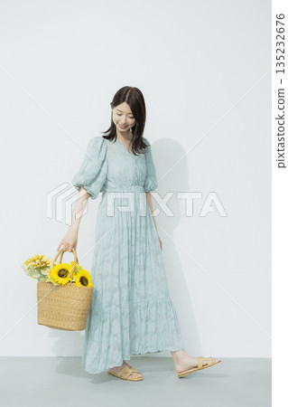 A young woman wearing a light blue dress 135232676