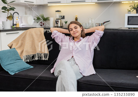 Young woman sits down to relax breathes deep and eases body and mind after long work with calm mood Young woman sits down to relax breathes deep and eases body and mind after long work with calm mood 135233890
