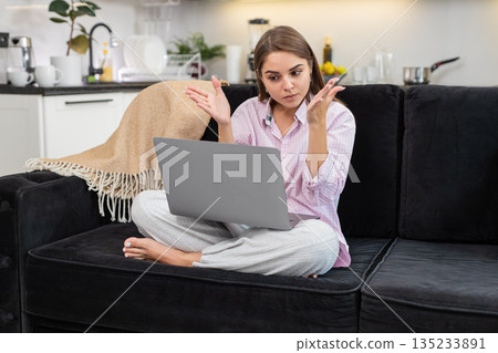 Young woman argues heated with coworkers on video meeting gestures with wide palm ends call laptop Young woman argues heated with coworkers on video meeting gestures with wide palm ends call laptop 135233891