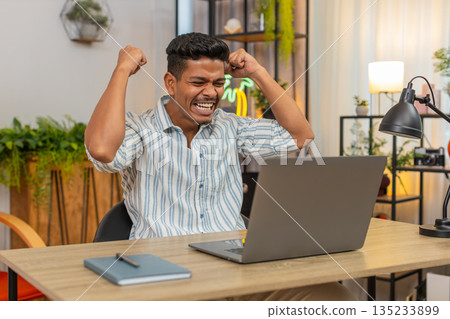 Indian man says wow as laptop alert shows prize news celebrates win feels proud of finished project 135233899