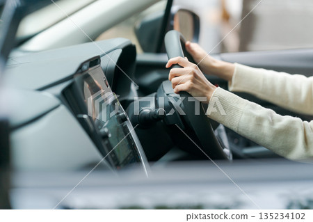 駕駛一輛車的女人的手 135234102