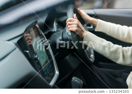 駕駛一輛車的女人的手 135234103