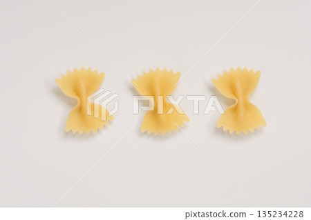 Italian dry farfalle pasta over white background with shadow top view Italian dry farfalle pasta over white background with shadow top view 135234228