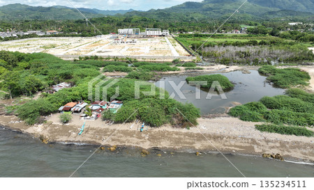 Land grabbing damage for nature displacing communities, drone aerial worsening poverty and food insecurity, damaging environment, deforestation, soil. Mangrove salt water wetland near ocean beach 135234511