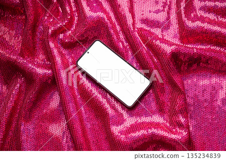 Smartphone with blank screen on sparkly pink sequin fabric backdrop. Smartphone with blank screen on sparkly pink sequin fabric backdrop. 135234839