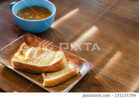 在清晨的陽光下，享用著法式吐司和湯的早餐。 135235799