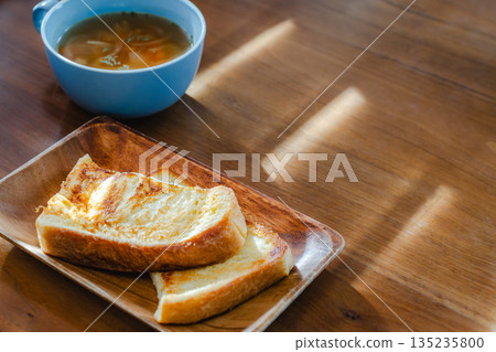 在清晨的陽光下，享用著法式吐司和湯的早餐。 135235800