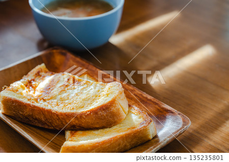 在清晨的陽光下，享用著法式吐司和湯的早餐。 135235801