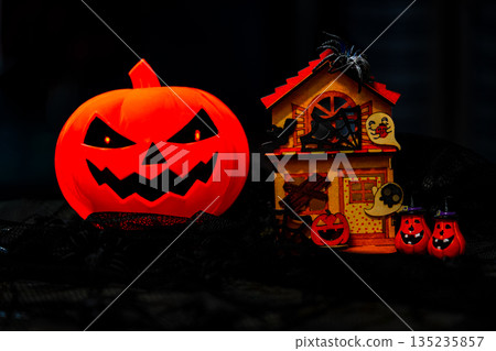 Plastic Pumpkin carved into spooky demon face for halloween Plastic Pumpkin carved into spooky demon face for halloween 135235857