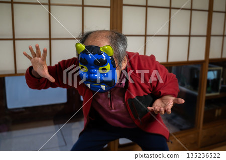 Elderly man wearing a demon mask during Setsubun Elderly man wearing a demon mask during Setsubun 135236522