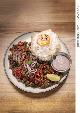 Pad Kra Pao Pork and Holy Basil Stir fry traditional thai food meal on table at restaurant in phuket thailand Pad Kra Pao Pork and Holy Basil Stir fry traditional thai food meal on table at restaurant in phuket thailand 135236578