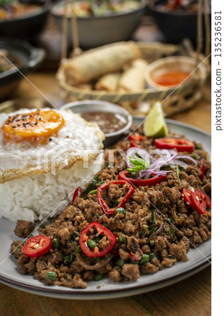 Pad Kra Pao Pork and Holy Basil Stir fry traditional thai food meal on table at restaurant in phuket thailand Pad Kra Pao Pork and Holy Basil Stir fry traditional thai food meal on table at restaurant in phuket thailand 135236581