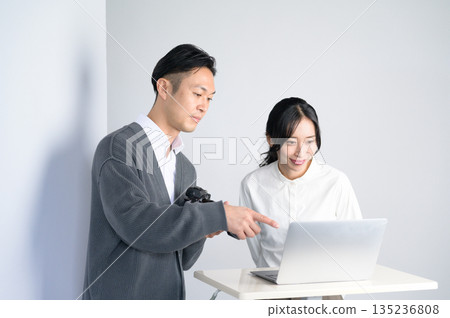Men and women checking photos on a computer in a studio 135236808