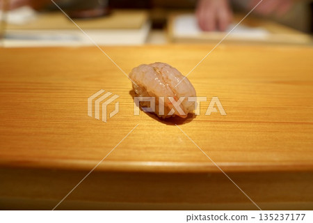 A masterpiece of Edomae sushi: fresh shrimp nigiri with a sweet taste and red vinegar rice 135237177