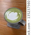 A cup of hot matcha on the wooden table 135237980