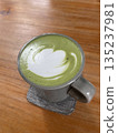 A cup of hot matcha on the wooden table 135237981