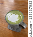 A cup of hot matcha on the wooden table 135237982