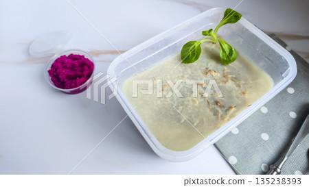 Cold meat jelly. Congealed broth in a transparent bowl. Horseradish next to it. Cold meat jelly. Congealed broth in a transparent bowl. Horseradish next to it. 135238393